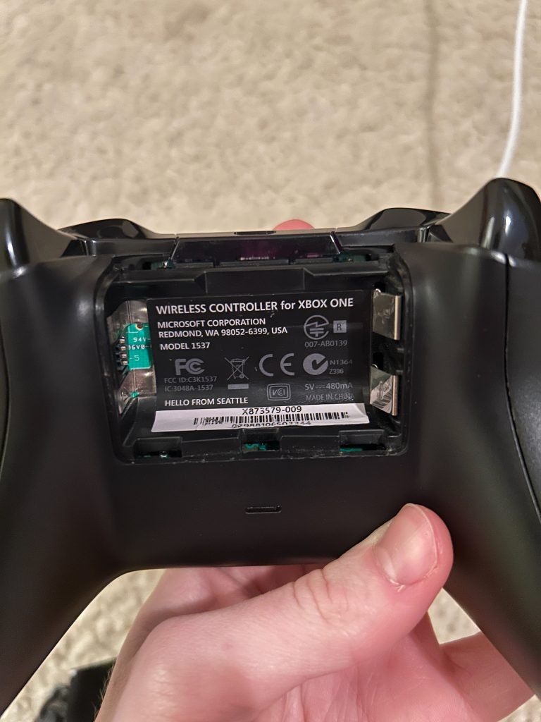 There's a screw under the sticker, but I used hot air to peel it off without damaging it
